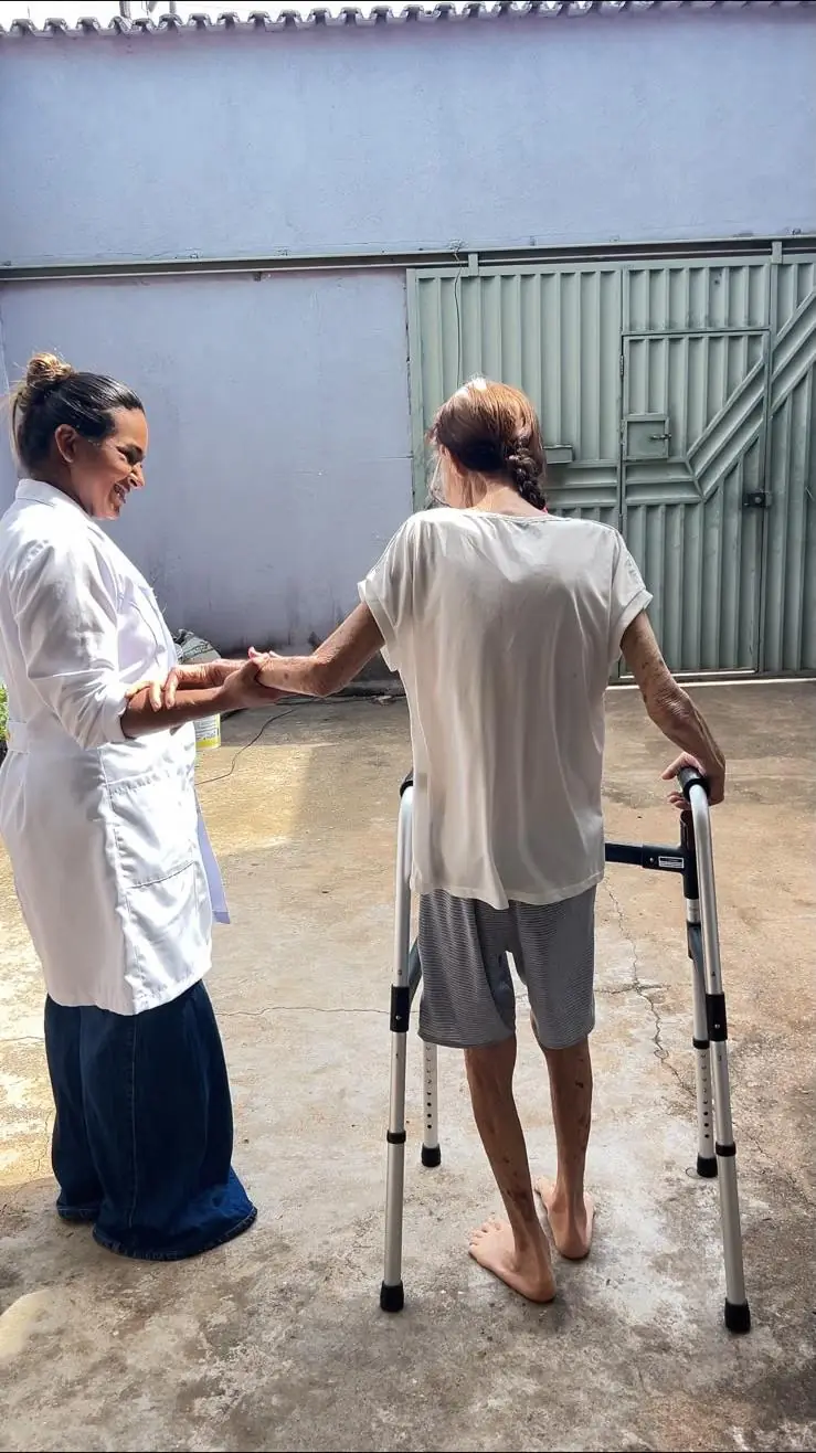 Dra. Francicléia auxiliando uma paciente a caminhar com andador